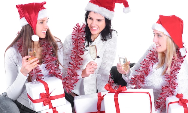 Tre giovani donne in cappelli di Babbo Natale con regali di Natale a