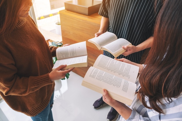 Tre giovani in piedi in cerchio e si sono divertiti a leggere libri insieme