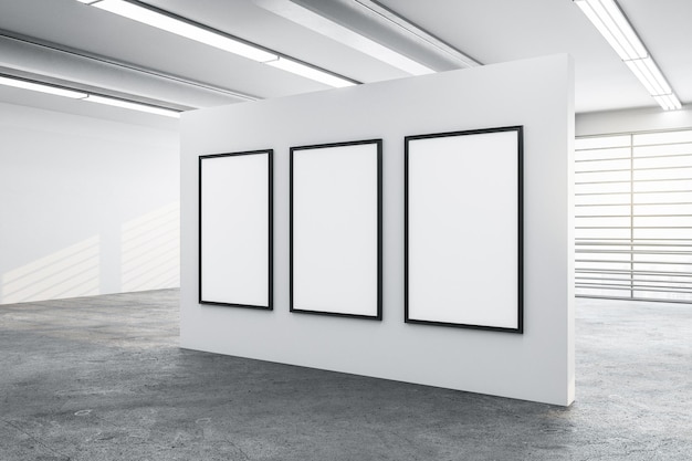 Tre grandi poster bianchi su una parete bianca.