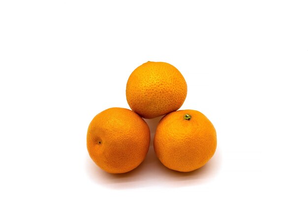 Tre mandarini succosi da vicino isolati su uno sfondo bianco