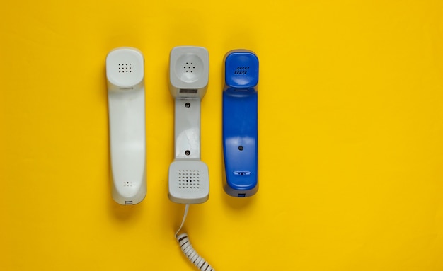 Tre microtelefoni dell'ufficio su colore giallo