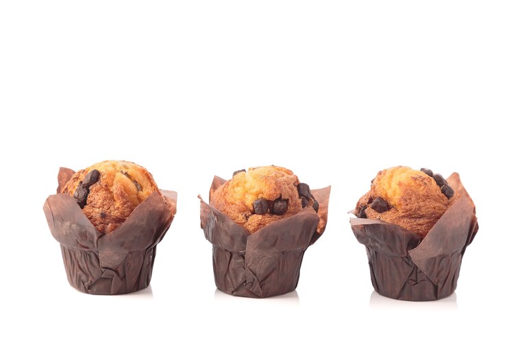 Tre muffin al cioccolato isolati su uno sfondo bianco con copia spazio.