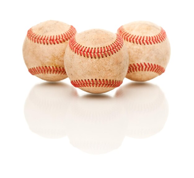 Tre palle da baseball isolate su bianco riflettente