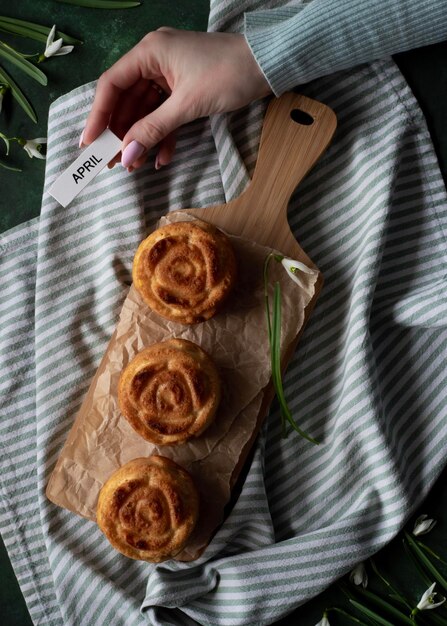 Tre pasticcini su una tavola di legno con un biglietto che dice aprile