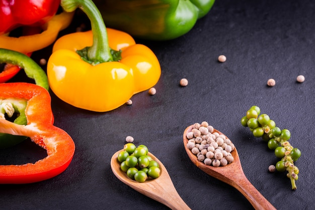 Tre peperoni dolci su un fondo di legno, cucinando insalata di verdure