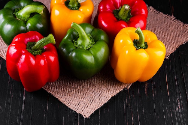 Tre peperoni dolci su un tavolo di legno, cucina insalata di verdure