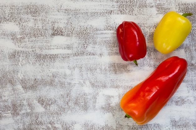 Tre peperoni freschi colorati su sfondo bianco