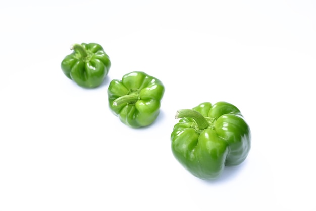 Tre peperoni verdi su sfondo bianco