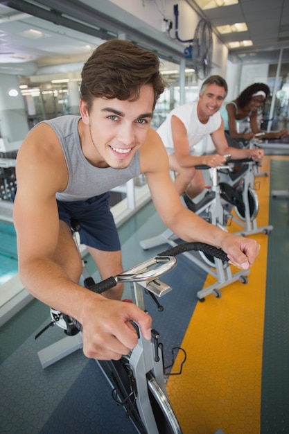 Tre persone in forma che lavorano su cyclette