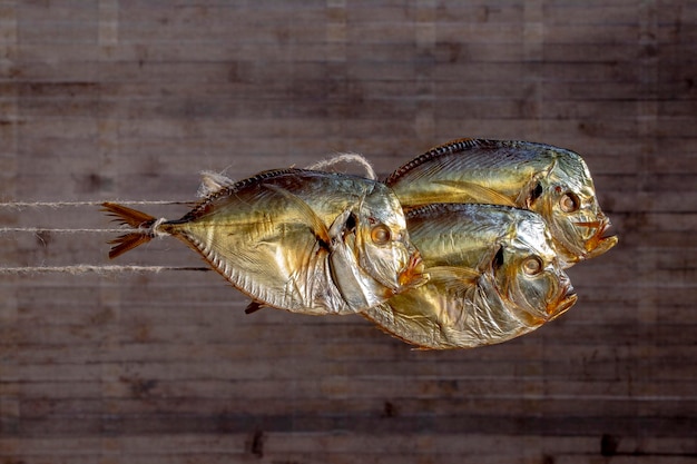 Tre pesce di mare affumicato Selene primo piano su una stringa