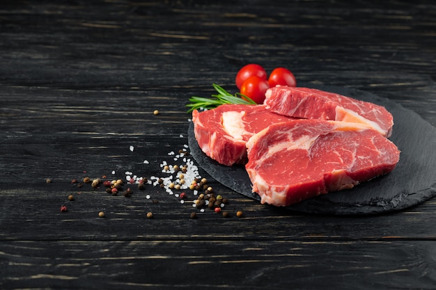 Tre pezzi di succosa carne cruda su un tagliere di pietra