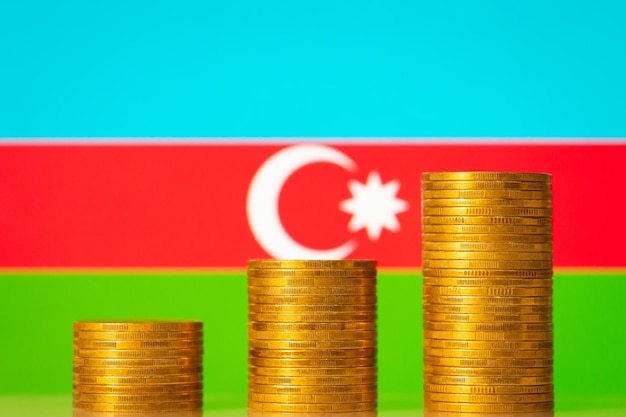 Tre pile di monete davanti alla bandiera dell'Azerbaigian Sviluppo del concetto dell'Azerbaigian