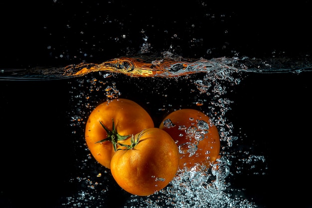 tre pomodori schizzano sull'acqua