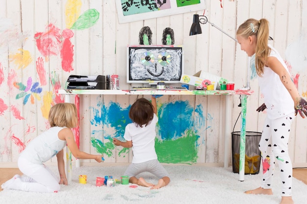 Tre ragazze che dipingono l'ufficio con la pittura a dita