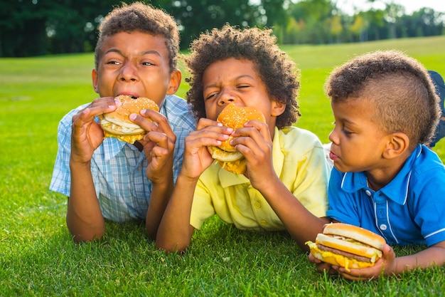 Tre ragazzi stanno mangiando.