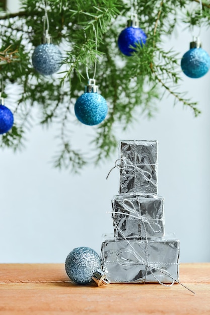 tre regali e una palla di Natale sullo sfondo di un albero di Natale e luci bokeh