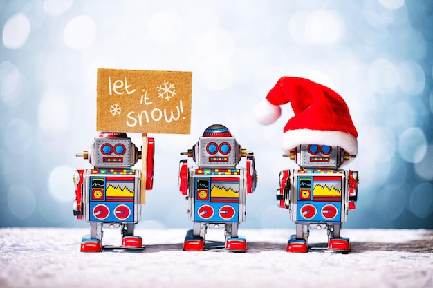 Tre robot retro che posano per Natale Lascia che neve Babbo Natale