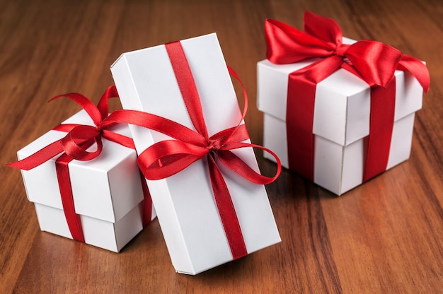 Tre scatole regalo bianche con nastro rosso