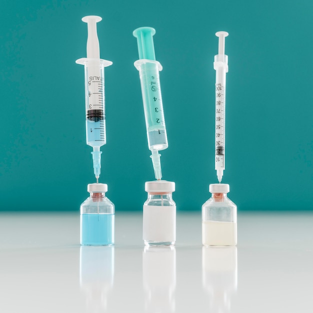 Tre siringhe bloccate in bottiglie di vaccino