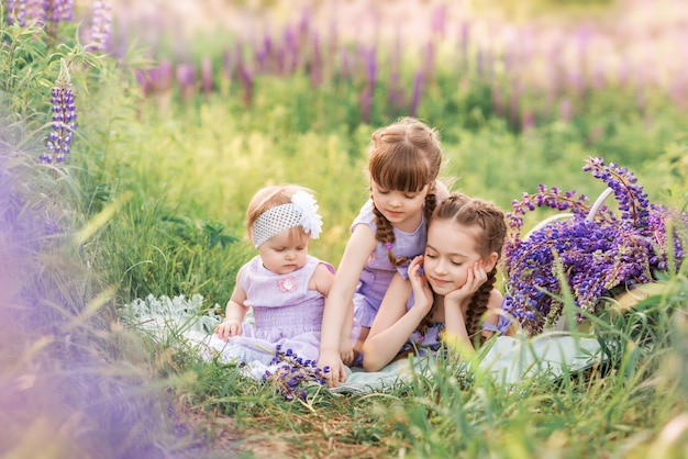 Tre sorelle in natura. Bambini nel prato con fiori