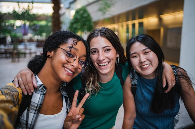 Tre studentesse universitarie che si fanno un selfie nel campus universitario durante una pausa di lezione