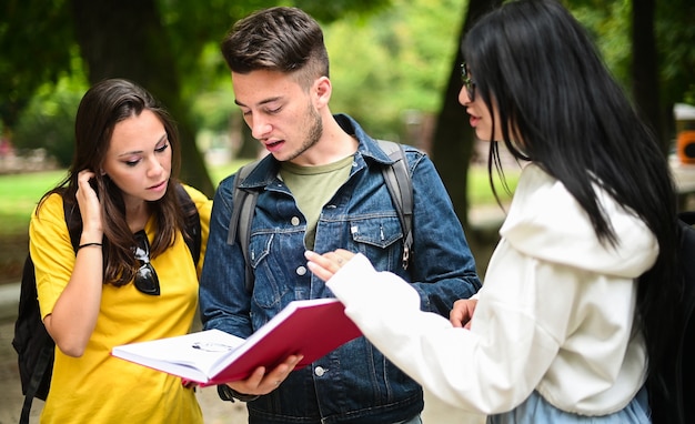 Tre studenti parlano tra loro all'aperto nel cortile di un college