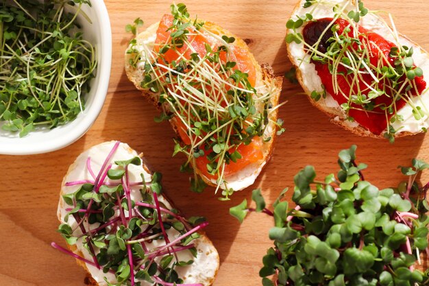 Tre toast con salmone al forno peperone dolce e microgreens closeup Gustosa colazione