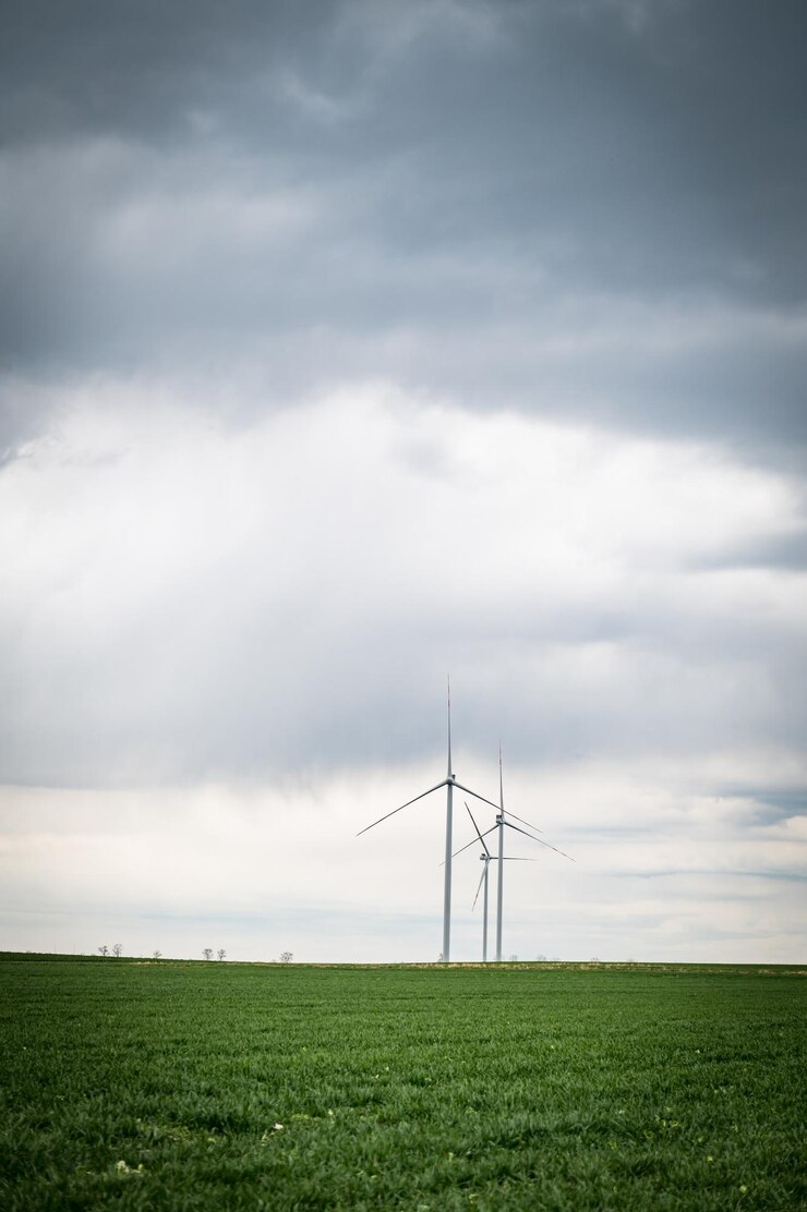Tre turbine eoliche di un parco eolico che producono energia rinnovabile immagine verticale Energia alternativa verde pulita Energia eolica per combattere i cambiamenti climatici e il riscaldamento globaleNessuna emissione o combustibili fossiliTerra