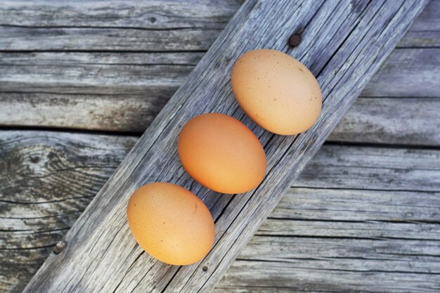 tre uova marroni sulla tavola di legno