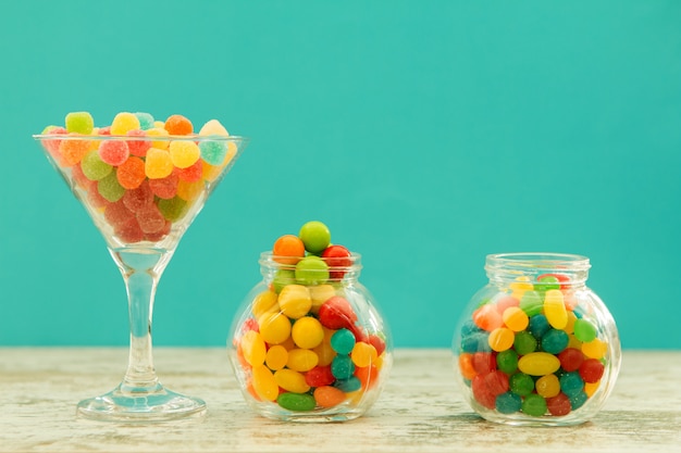 Tre vasi di vetro pieni di jellybeans con sfondo blu