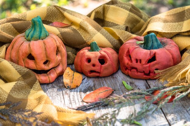 Tre zucche autunnali autunnali per Halloween avvolte con una sciarpa.