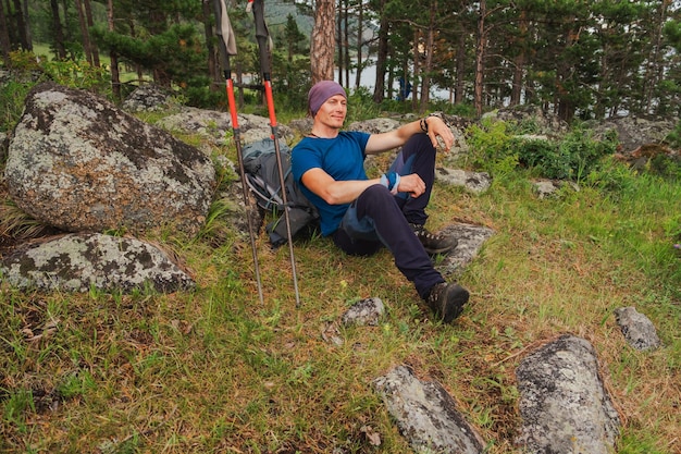 Trekking arrampicata scogliera avventura zaino in spalla uomo guardando bella vista escursionista con lo zaino si siede