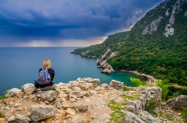 Trekking femminile che riposa su una scogliera a Olympos