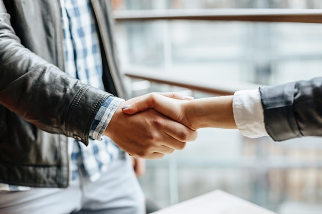 Tremante della mano della donna e dell'uomo. Stretta di mano dopo una buona cooperazione, donna d'affari che stringe la mano a un uomo d'affari professionista dopo aver discusso di una buona quantità di contratto. Concetto di affari.