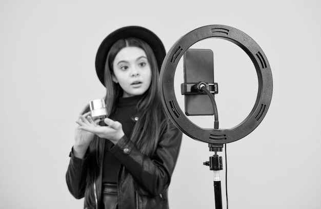 Trendy teen girl blogger usa la lampada a led selfie e lo smartphone sul blog del treppiede