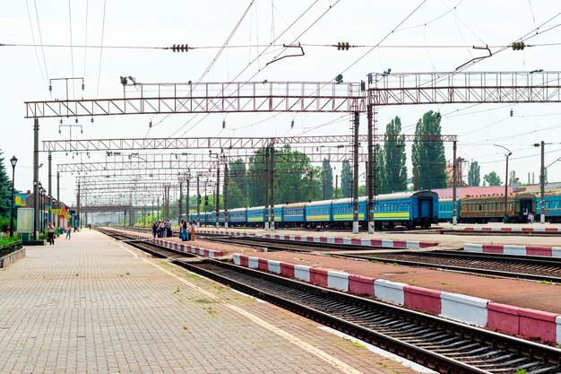 Treni ferroviari con carrozze e persone sul marciapiede della stazione ferroviaria