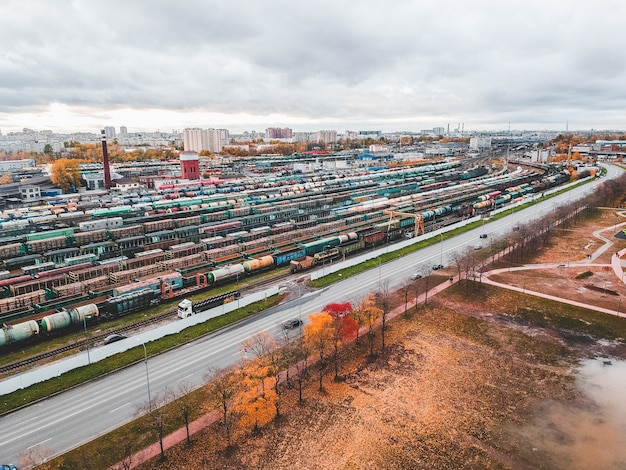 Treni merci. Vista aerea dei treni merci colorati sulla stazione ferroviaria. Carri con merci sulla ferrovia. Industria pesante. Scena concettuale industriale con i treni. Vista dal drone volante.