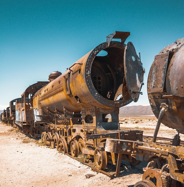 Treno abbandonato sui binari della ferrovia contro il cielo blu durante una giornata di sole