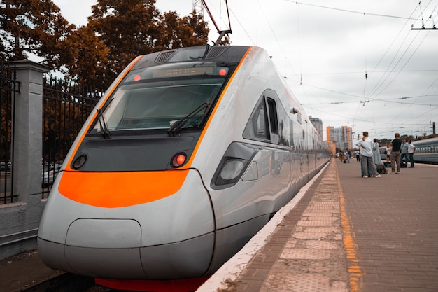 Treno arancione ad alta velocità alla stazione ferroviaria