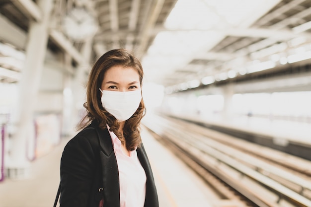 Treno aspettante della maschera d'uso della donna di affari.