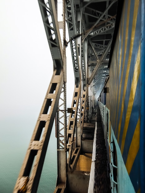 Treno che attraversa il ponte ferroviario sul fiume Godavari Rajahmundry India Foggy mattina vista