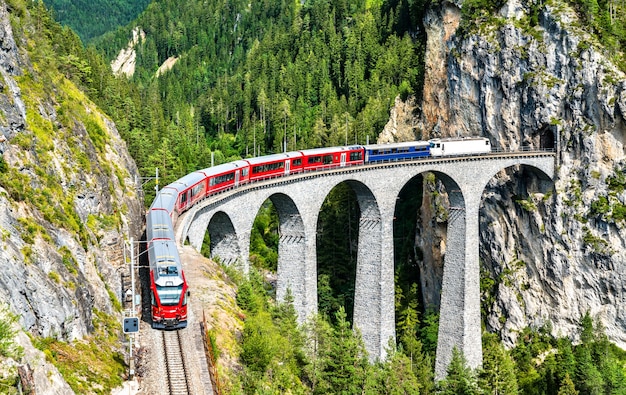 Treno passeggeri che attraversa il viadotto Landwasser nelle Alpi Svizzere