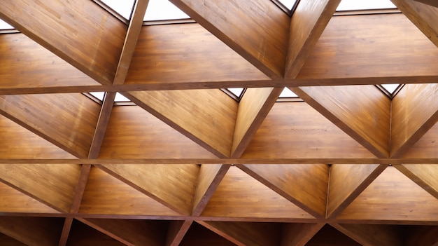 Triangoli di legno geometrici lussuosi in costruzione. Il concetto di architettura moderna, design e interni. Fondo di legno. Pensilina o tetto modulare.