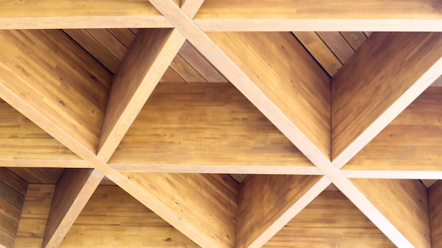Triangoli di legno geometrici lussuosi in costruzione. Il concetto di architettura moderna, design e interni. Fondo di legno. Pensilina o tetto modulare.