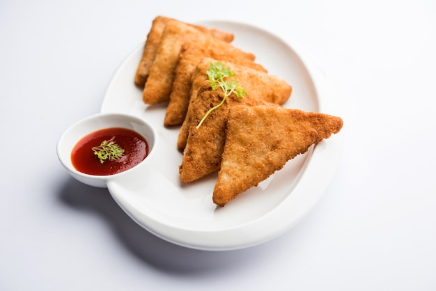 Triangoli di patate croccanti o batata vada ricoperti di pangrattato e poi fritti. servito con salsa di pomodoro. messa a fuoco selettiva