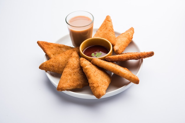 Triangoli di patate croccanti o batata vada ricoperti di pangrattato e poi fritti. servito con salsa di pomodoro. messa a fuoco selettiva