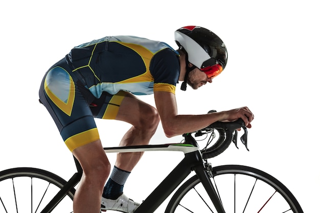 Triathlon atleta maschio ciclo di formazione isolato su bianco di sfondo per studio. Triatleta in forma caucasica che pratica nel ciclismo indossando attrezzature sportive. Concetto di stile di vita sano, sport, azione, movimento.