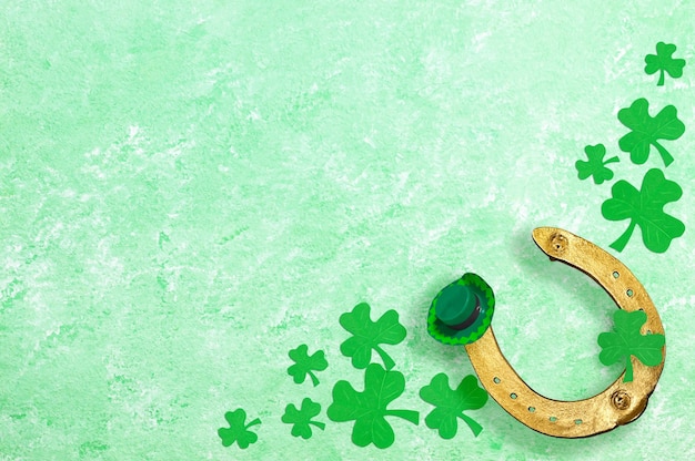 Trifoglio d'oro a ferro di cavallo trifogli cappello verde su sfondo verde per il giorno di San Patrizio