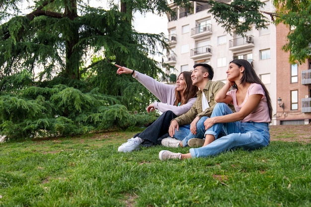 Trio eclettico Gioiosi giovani turisti Diversi e uniti che esplorano insieme il parco cittadino