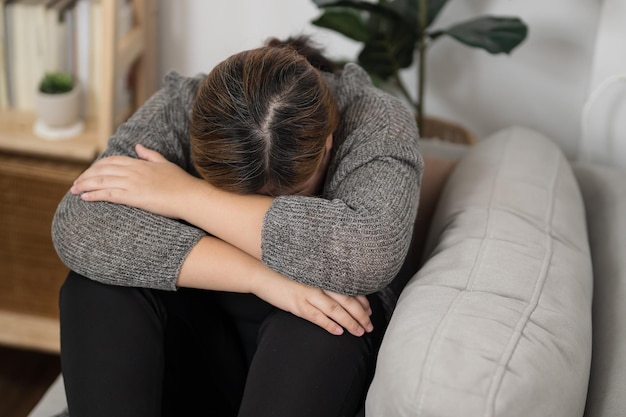 Triste donna in sovrappeso che pensa ai problemi sul divano ragazza sconvolta che si sente sola e triste per una cattiva relazione o donna depressa disturbo della salute mentale